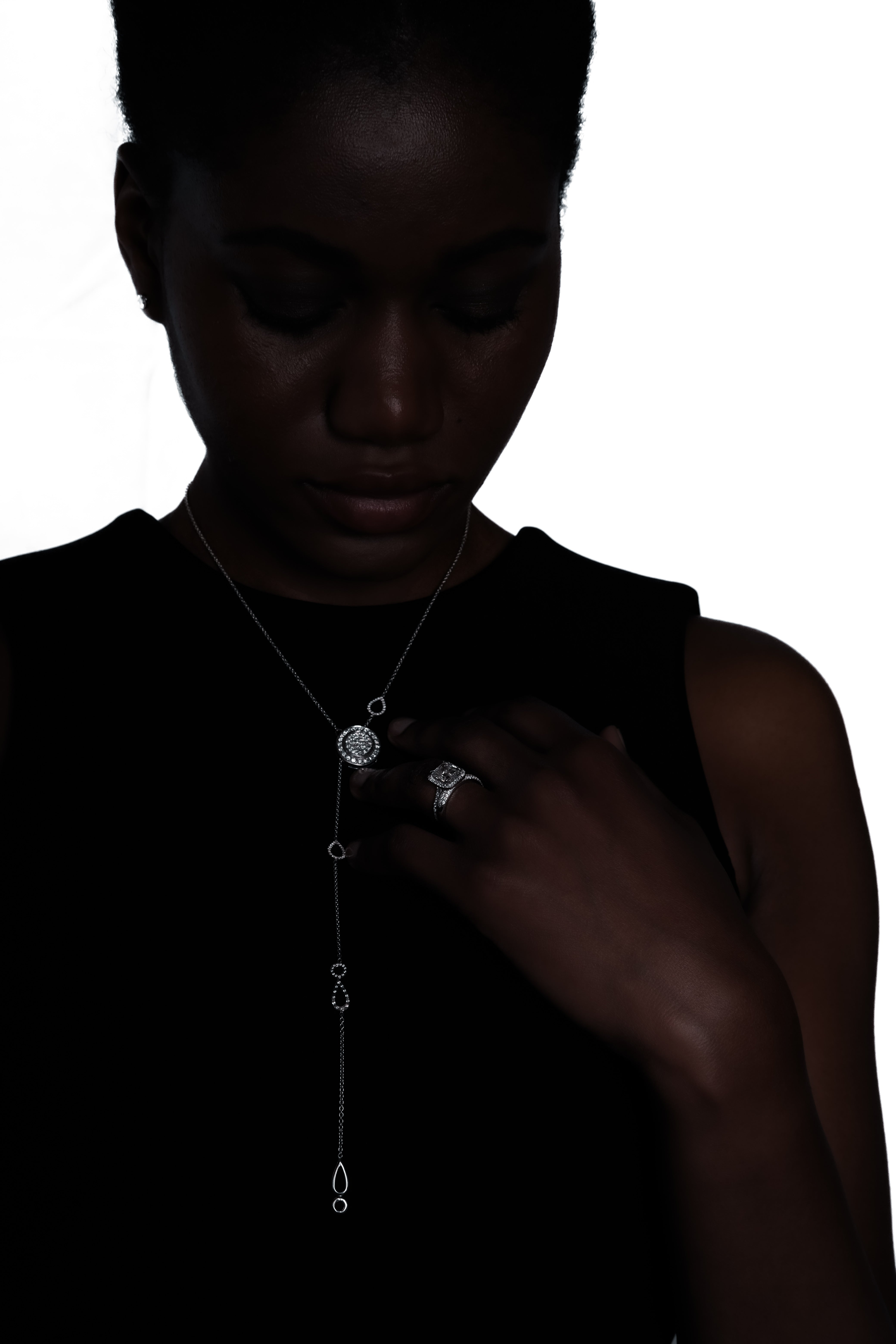 Femme portant le collier Temple de la Lune en platine et un anneau de fiançailles éthique signé AGUAdeORO — une alliance de poésie, de pureté et d'engagement.